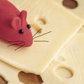 Toy mouse with painted mustache on flat slices of natural cheese with holes, close-up, top view Royalty Free Stock Photo