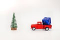 toy red truck carries a gift under the Christmas tree on a white background, copy space Royalty Free Stock Photo