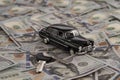 Toy retro car with keys on the background of dollar bills Royalty Free Stock Photo