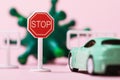 Toy road sign, car and coronavirus, closeup. Concept of travel ban due to the covid-19 pandemic