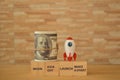 Toy rocket, money banknote with phrase BEGIN, KICK OFF, LAUNCH and MAKE A START
