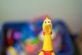 Toy rubber shriek yellow chicken on blur toy background in messy