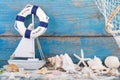 Toy sailboat and life buoy with seashells and starfish an a wood Royalty Free Stock Photo