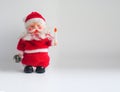 Toy Santa Claus with a candle and a bell. Christmas background with a copy space Royalty Free Stock Photo