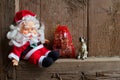 Toy Santa Claus figurine dog and a bag with Christmas gifts on vintage wooden background. Royalty Free Stock Photo