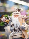 Toy Santa Claus standing against a festive bright soft focused background.