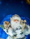 Toy Santa Claus standing against starry dark blue background.