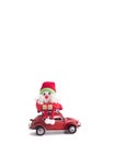 Toy Santa sitting on the roof of red retro car Volkswagen Beetle on white