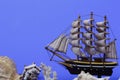 Toy ship on a blue background. Near many seashells