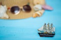 Toy ship, blurred hat, sunglasses and shells on back Royalty Free Stock Photo