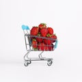 Toy shopping cart or trolley full of ripe large red strawberries isolated on white background. Berry harvest sale Royalty Free Stock Photo