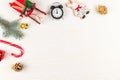 Toy sleigh of santa claus, figurine of a deer, christmas tree branch, pine cones, bell, alarm clock and lollipop staff on a white Royalty Free Stock Photo