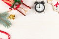 Toy sleigh of santa claus, figurine of a deer, christmas tree branch, pine cones, bell, alarm clock and lollipop staff on a white Royalty Free Stock Photo