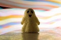 A toy smiling ghost stands against a background of multicolored stripes of bright light Royalty Free Stock Photo