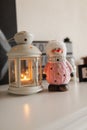 A toy snowman next to a white lantern