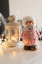 A toy snowman next to a white lantern
