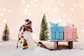 Toy snowman pulling small wooden sleigh with a Christmas gifts. Royalty Free Stock Photo