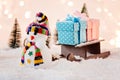 Toy snowman pulling small wooden sleigh with a Christmas gifts. Royalty Free Stock Photo