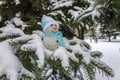 A toy snowman stands on the snow-covered thorny spruce branches Royalty Free Stock Photo