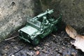 Toy soldier drive his jeep on a soak soil ground