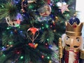 Toy soldier wooden nutcracker statue standing in front of decorated Christmas tree Royalty Free Stock Photo