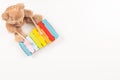 Toy teddy bear playing on colorful xylophone. Kid toys on white background. Early childhood music education. Top view Royalty Free Stock Photo