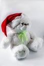 Toy teddy bear wearing Santa hat, on a light background. Royalty Free Stock Photo