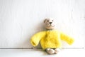 Toy Teddy Bear on yellow t-shot sitting on table on white background Royalty Free Stock Photo
