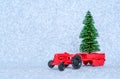 Toy tractor delivering a miniature Christmas tree