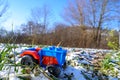 Toy tractor red and blue in the snow on a meadow Royalty Free Stock Photo