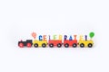 Toy train with colorful letters on top arranged in word celebrate