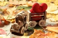 Toy train with hearts on autumn foliage. Concept of love of St. Valentine`s Day greeting card Royalty Free Stock Photo