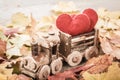 Toy train with hearts on autumn foliage. Concept of love of St. Valentine`s Day greeting card Royalty Free Stock Photo