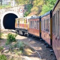 Toy Train moving on mountain slopes, beautiful view, one side mountain, one side valley moving on railway to the hill, among green Royalty Free Stock Photo