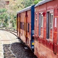 Toy Train moving on mountain slopes, beautiful view, one side mountain, one side valley moving on railway to the hill, among green Royalty Free Stock Photo