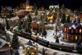 A toy train on a railway in the middle of a miniature winter city