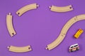 Toy train and wooden rails pieces on purple violet background Royalty Free Stock Photo