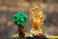A toy tree and a statue of Buddha in close-up Royalty Free Stock Photo