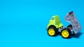 Toy truck car on a blue background - construction equipment for children. Bright children`s plastic toys, dump truck