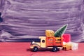 Toy truck carries gifts and a Christmas tree. Photo in vintage style Royalty Free Stock Photo