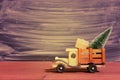 Toy truck carries gifts and a Christmas tree. Photo in vintage style Royalty Free Stock Photo