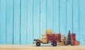 Toy truck carries gifts and a Christmas tree. Photo in vintage style Royalty Free Stock Photo