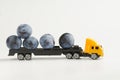 A toy truck carrying fresh plums. White background. The concept of delivering oversized items and fresh farm fruits from the new Royalty Free Stock Photo