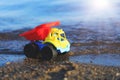 Toy truck on the gold sandy beach. Red, blue and yellow car on t Royalty Free Stock Photo
