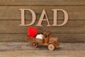 Toy truck with red heart against text dad
