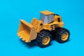 Toy typewriter tractor bulldozer on a blue background. Toy for children Royalty Free Stock Photo