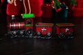 Toy vintage steam locomotive on floor under a decorated Christmas tree and gifts. Xmas toy train on Christmas tree background. Chr Royalty Free Stock Photo