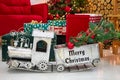 Toy vintage train on the floor under a decorated Christmas tree against the background of a garland of bokeh lights Royalty Free Stock Photo