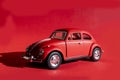 Toy Volkswagen Beetle on a red background, close-up, illustrative editorial. Date and location: Kiev, Ukraine September 2020 Royalty Free Stock Photo