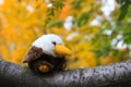 A toy white and brown bird sits on a tree in a leaf fall against a background of yellow trees and leaves. Autumn Park Royalty Free Stock Photo